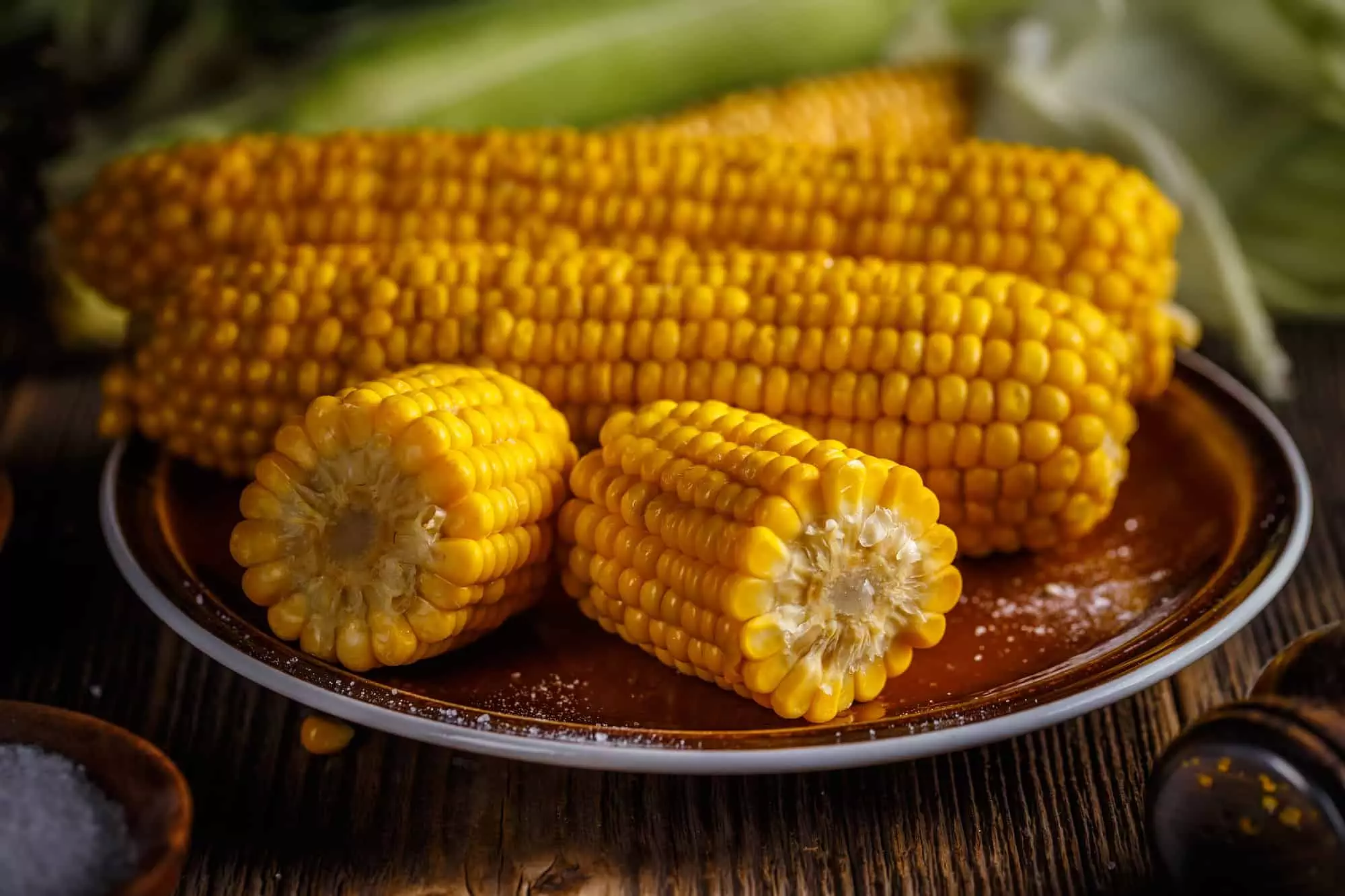 cooking corn in the microwave is quick and easy for these corn cobs sitting on a plate