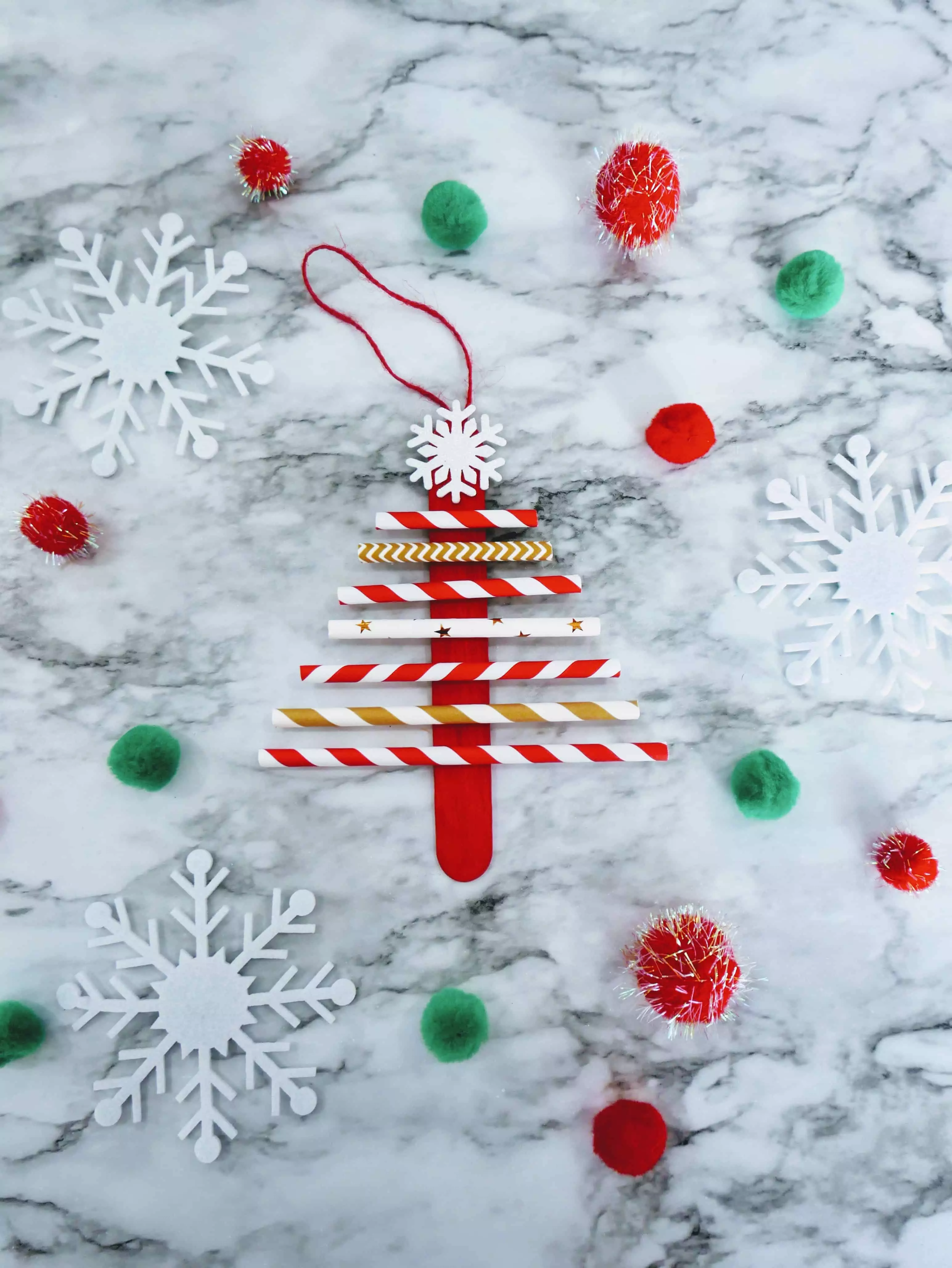 paper straw Christmas tree craft with poms and snowflakes.