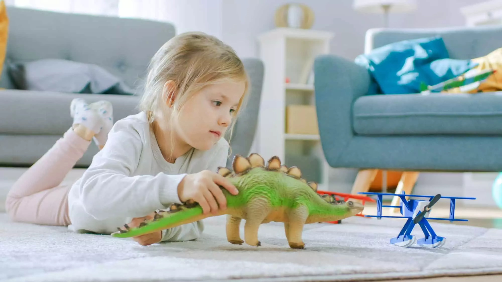 little girl playing with dinosaur toys for toddlers