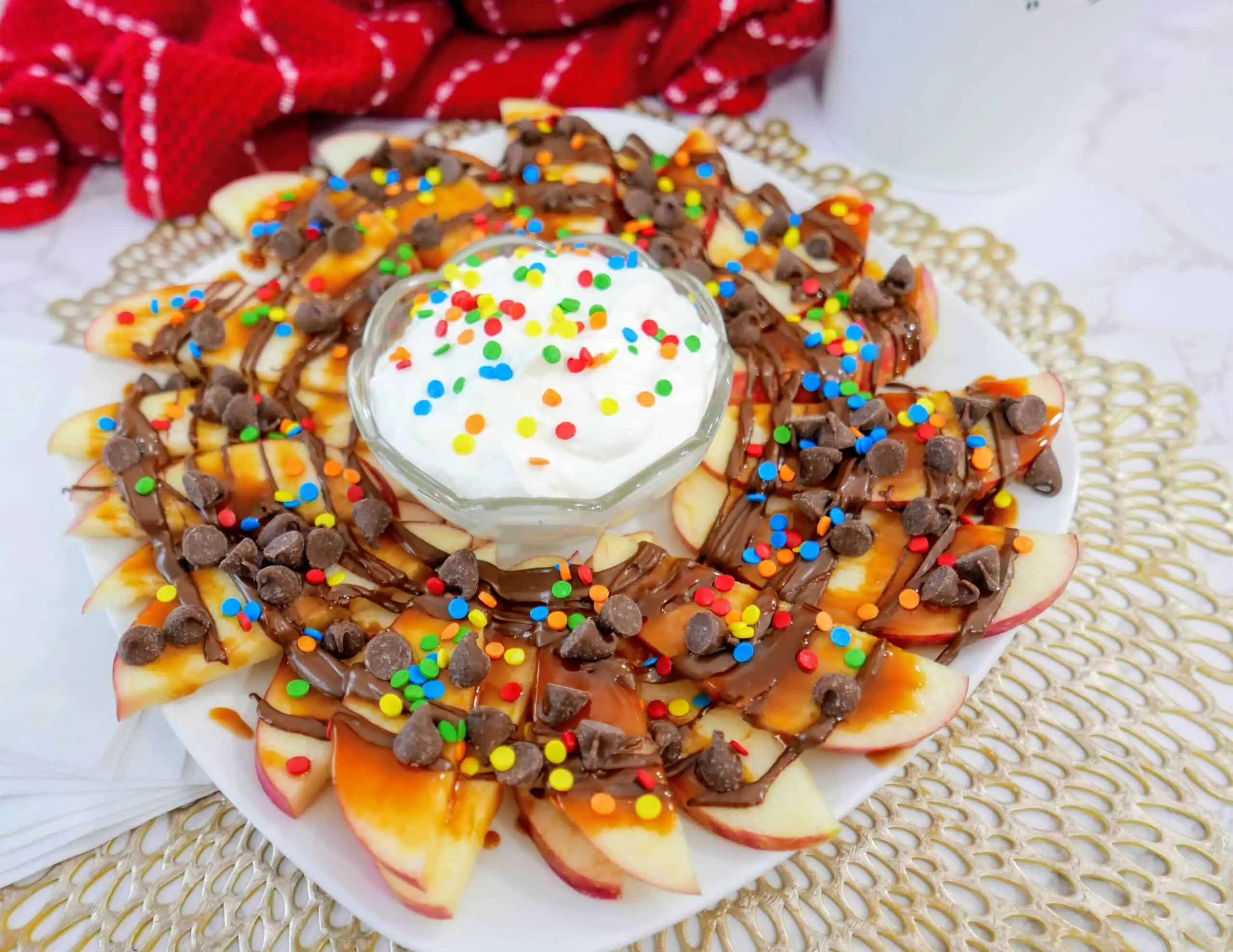 apple nachos with fruit dip on a plate