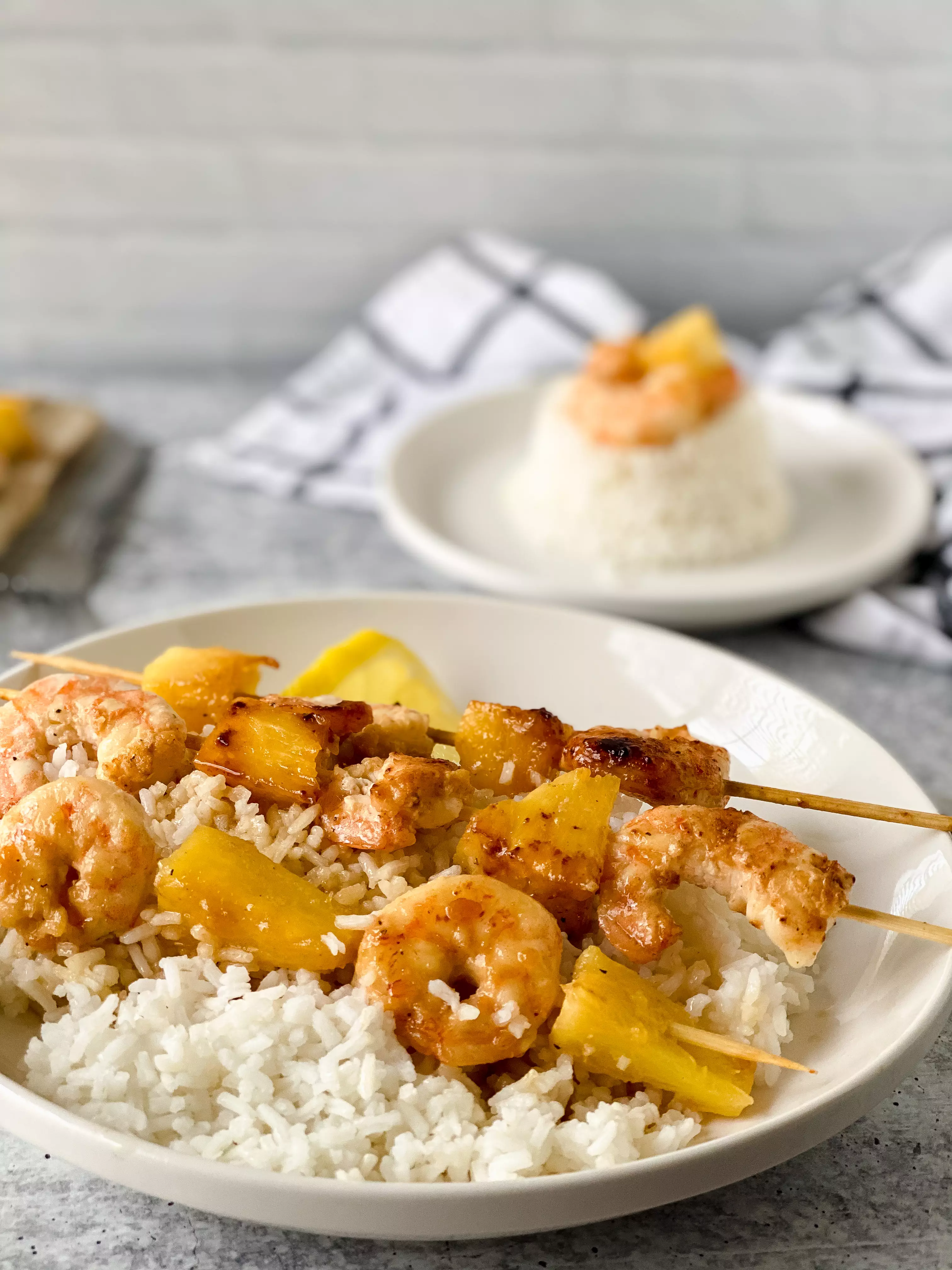 prepared honey garlic shrimp skewers on a bed of rice