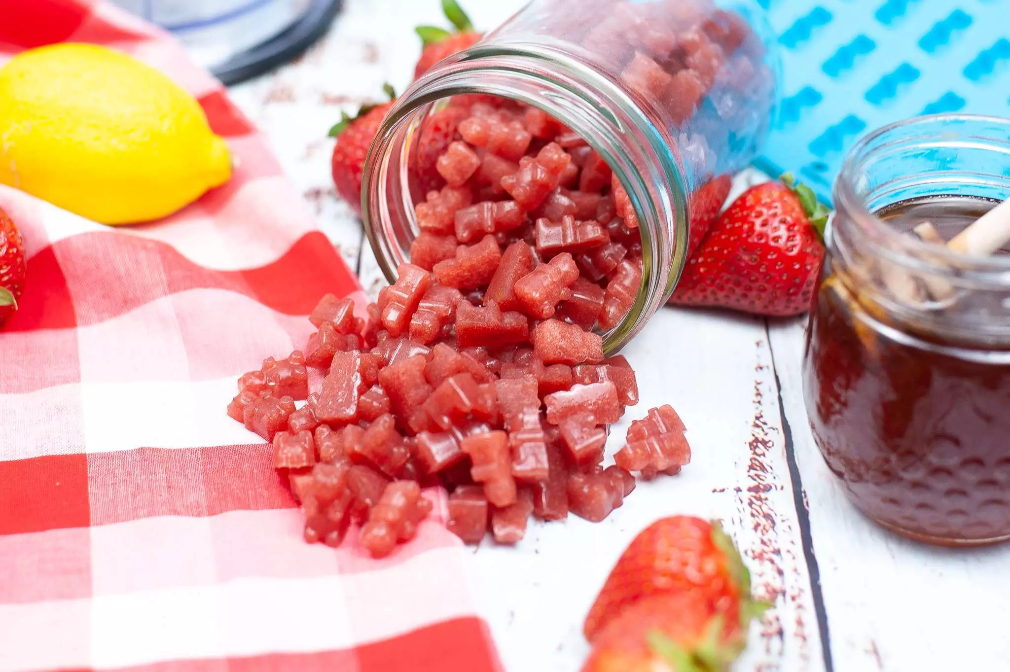 homemade strawberry gummies spilling out of mason jar