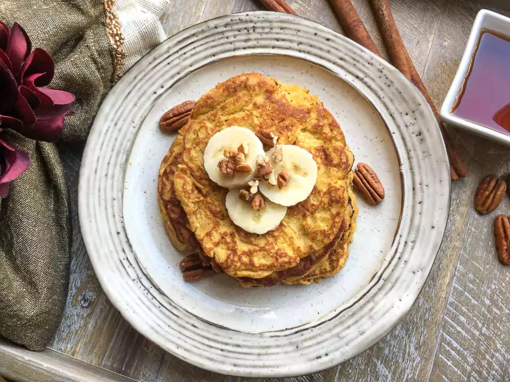 easy gluten-free, paleo-friendly pancakes topped with banana slices and nuts on a plate