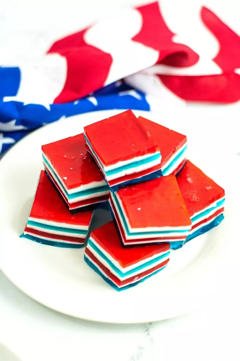 stacked red white and blue jello jigglers on a plate