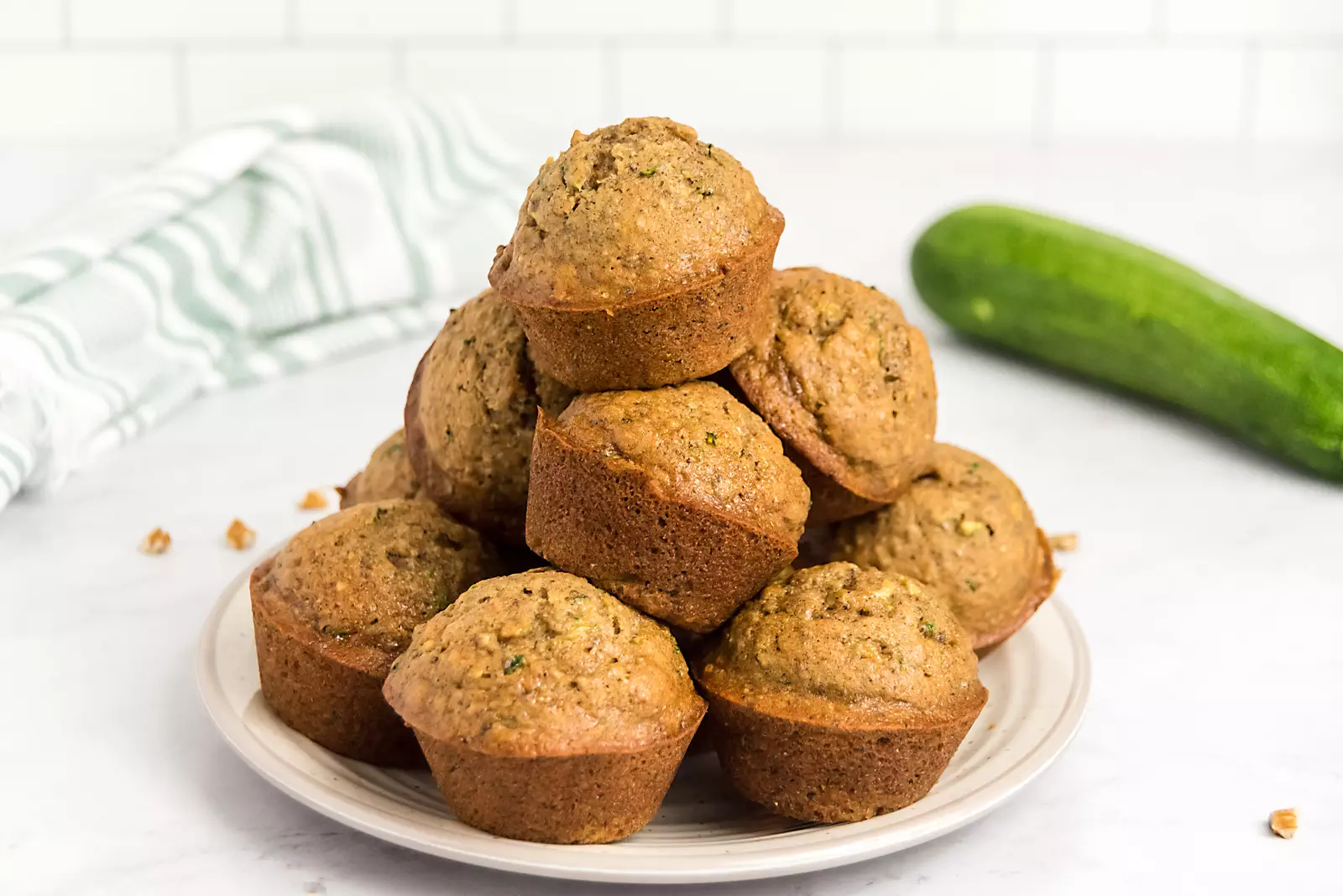 baked zucchini muffins stacked on a plate