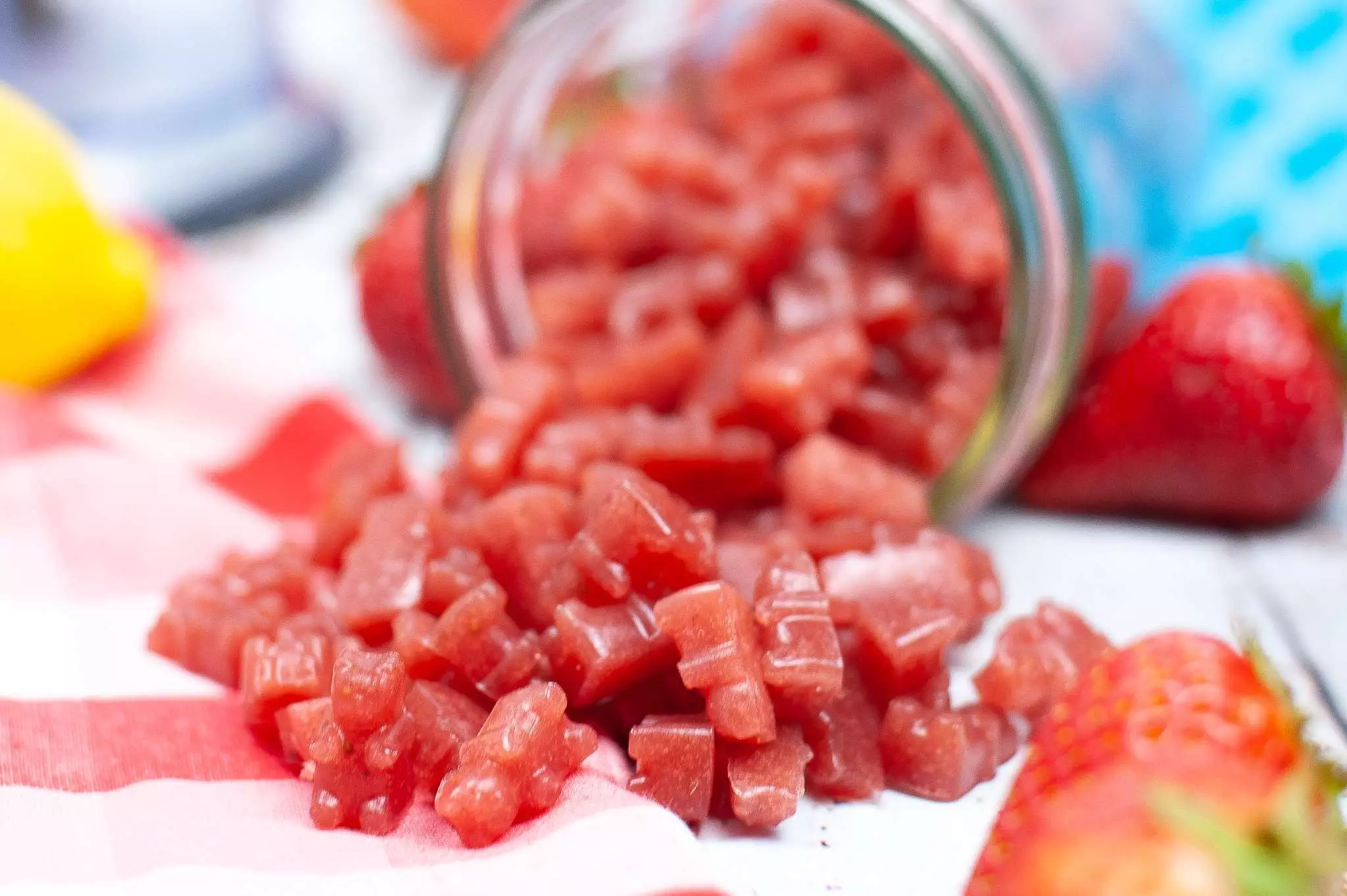 homemade strawberry gummies spilling out of a mason jar
