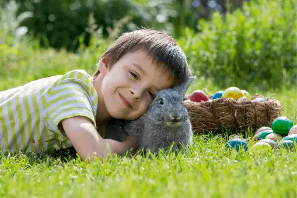 boy with basket of eggs and bunny for easter basket ideas for boys