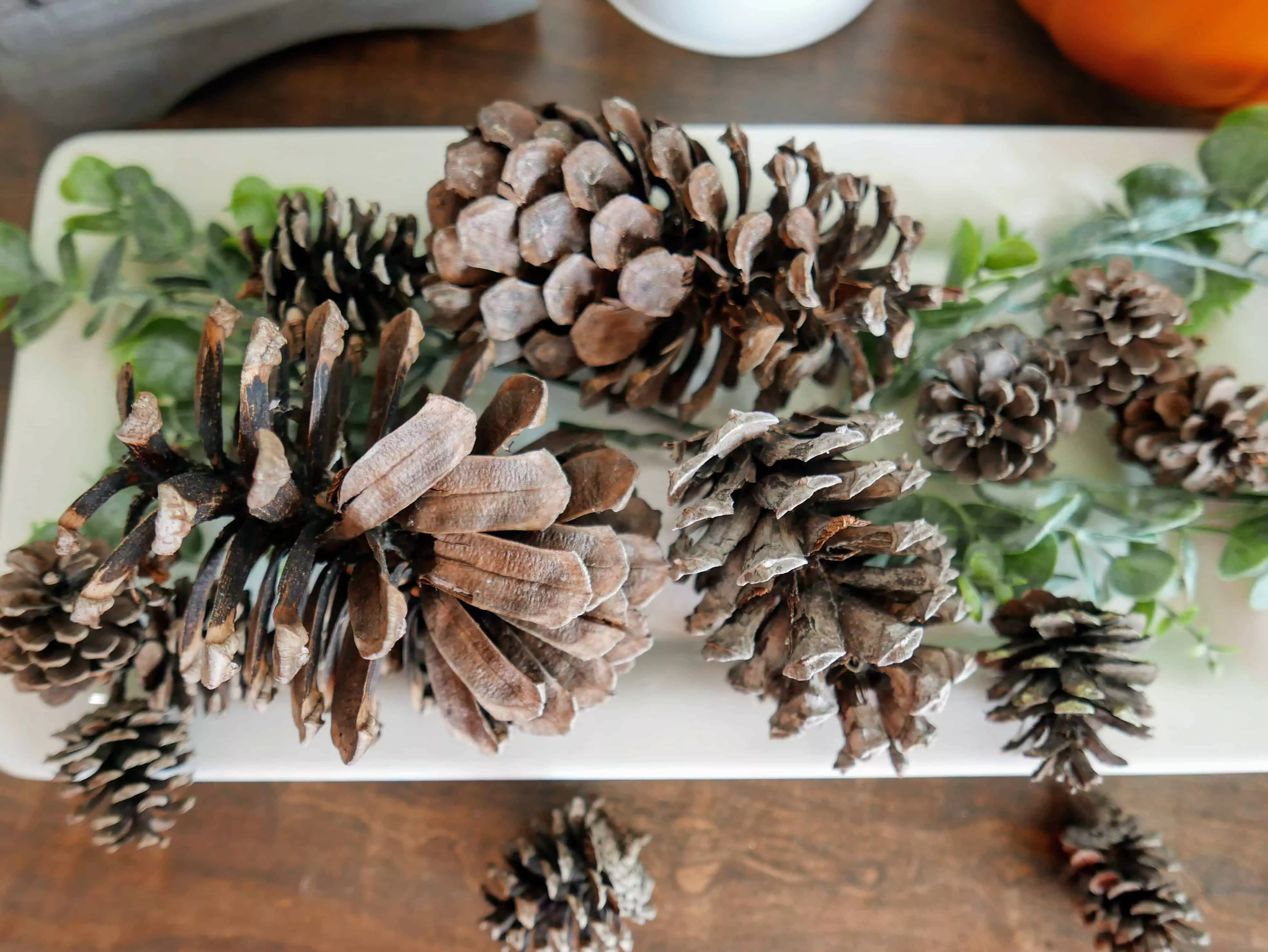 scented pinecones on a tray with greenery