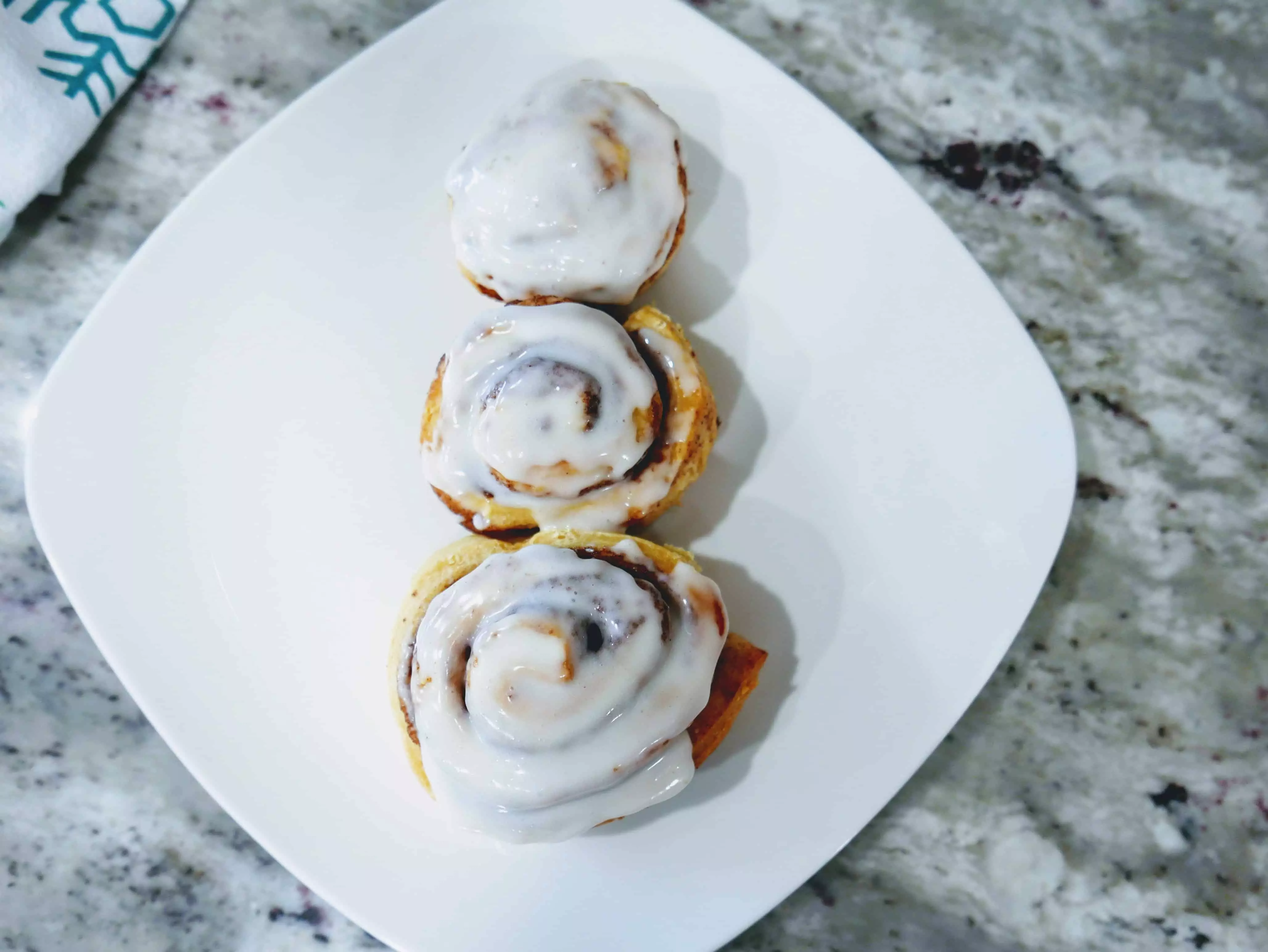 cinnamon rolls assembled like a snowman with icing on top