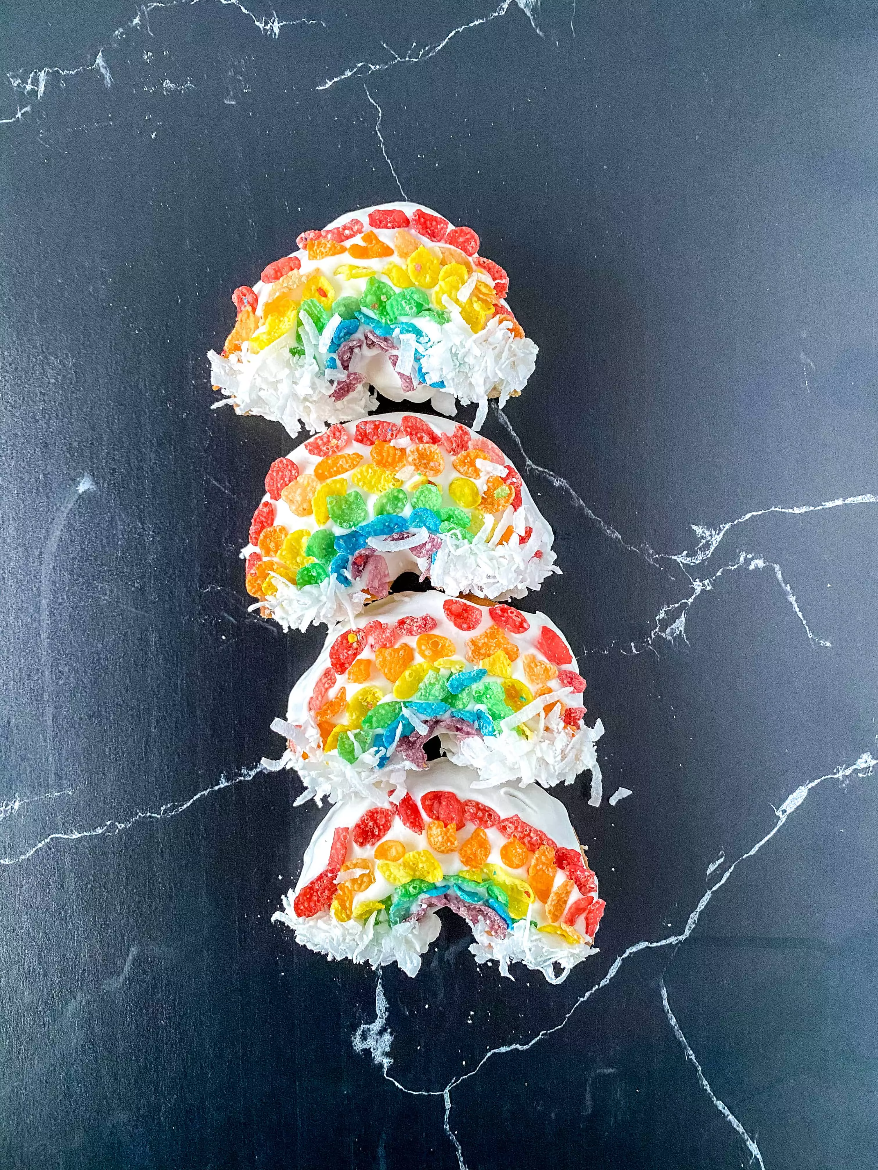 Rainbow Donuts! Make these fun donuts with fruity pebbles, white frosting, and coconut! They are SO easy to make that you