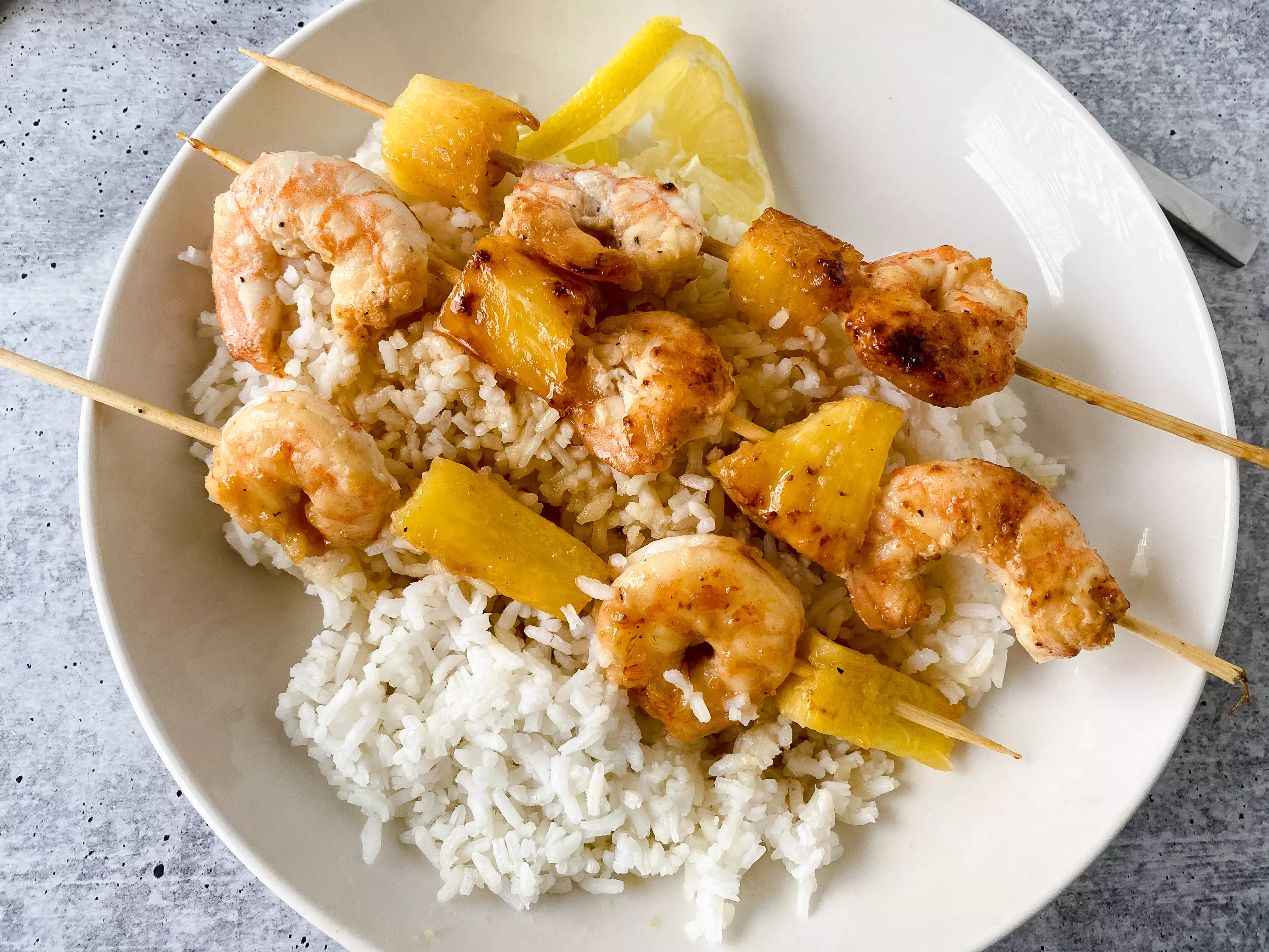 prepared honey garlic shrimp and pineapple kabobs on rice from above