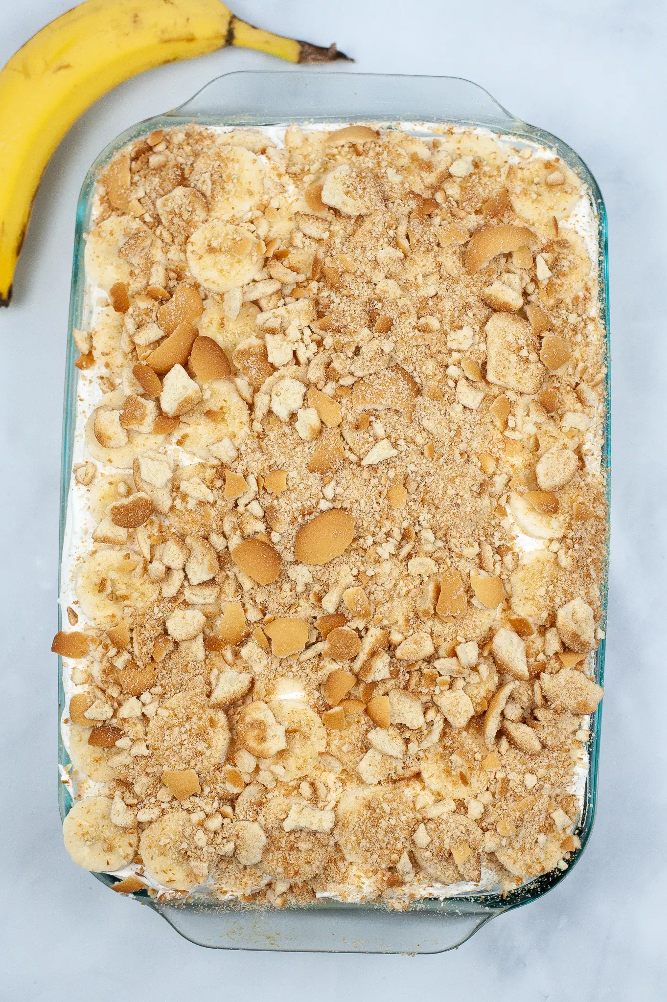 crumbled vanilla wafers on top of the banana pudding poke cake