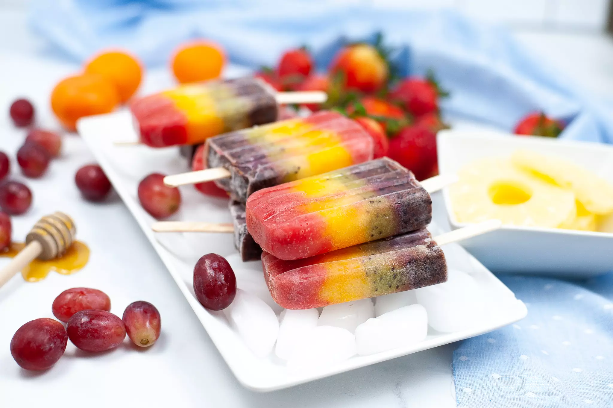 Cocomelon rainbow popsicles stacked on a plate of ice