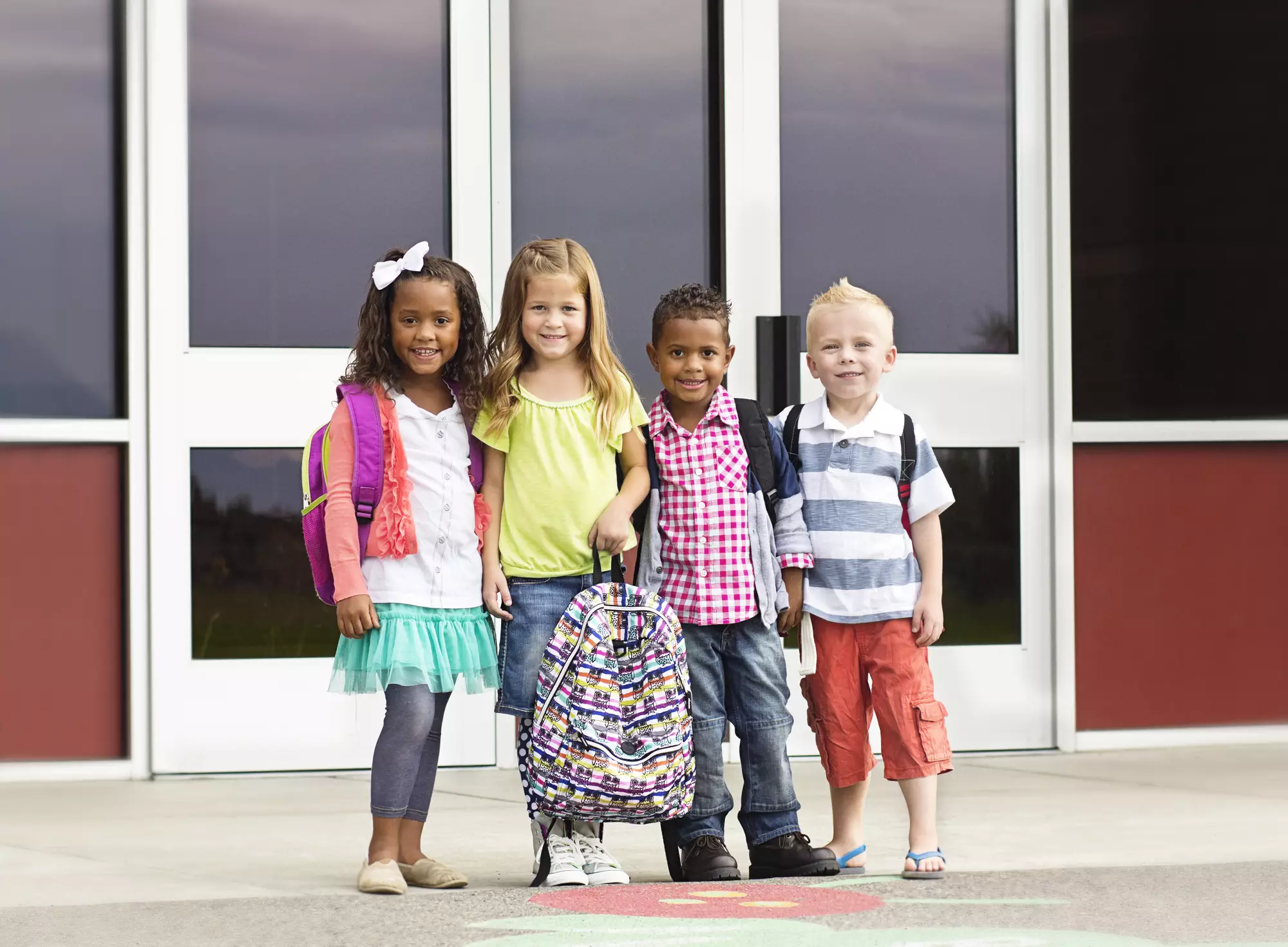 back-to-school preparation tips for first day success - group of kids smiling outside school door