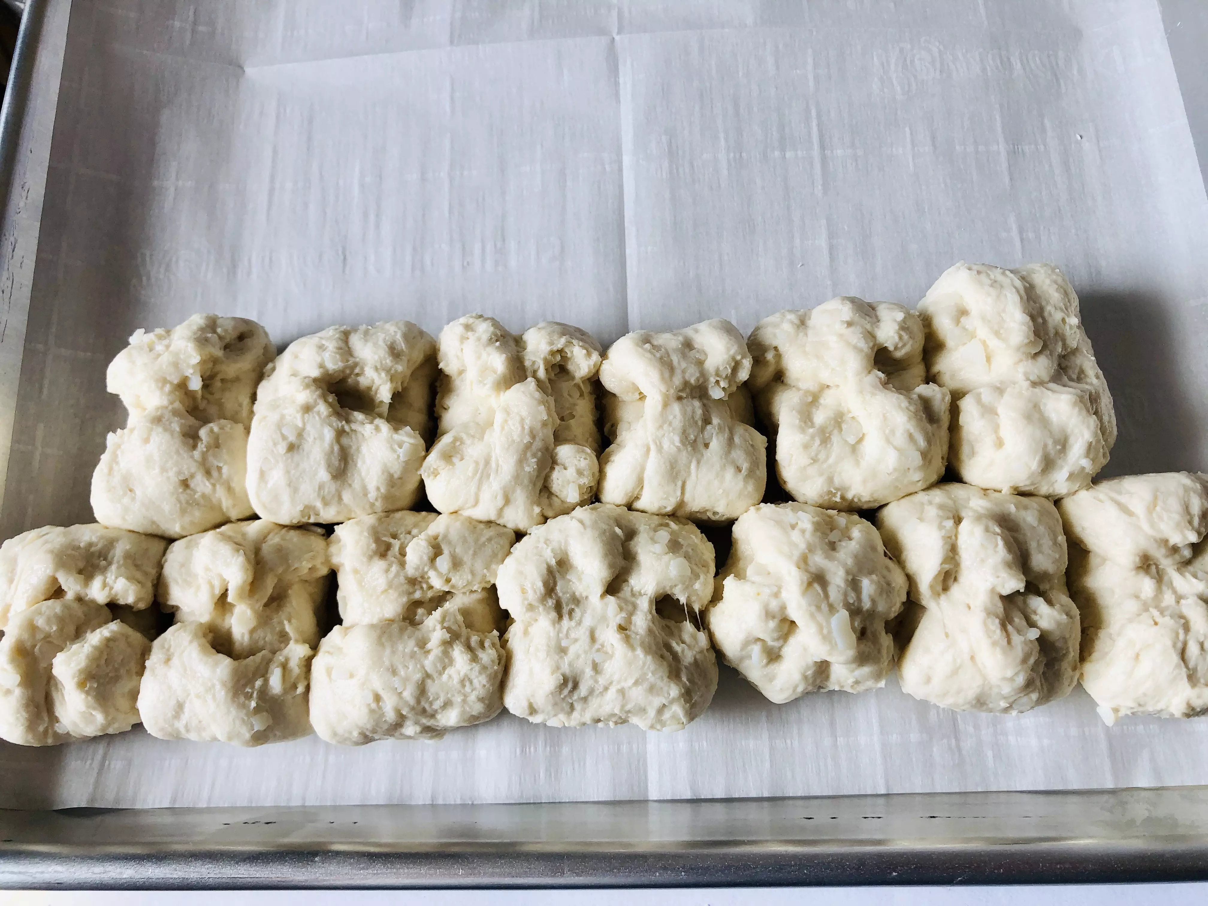 adding biscuit balls to a baking tray