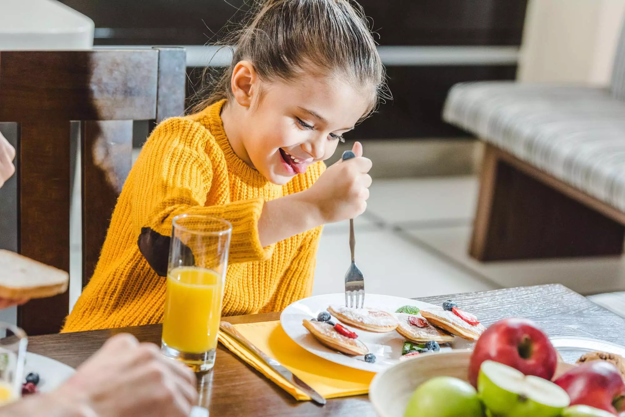 girl eating breakfast  as part of her school morning routine